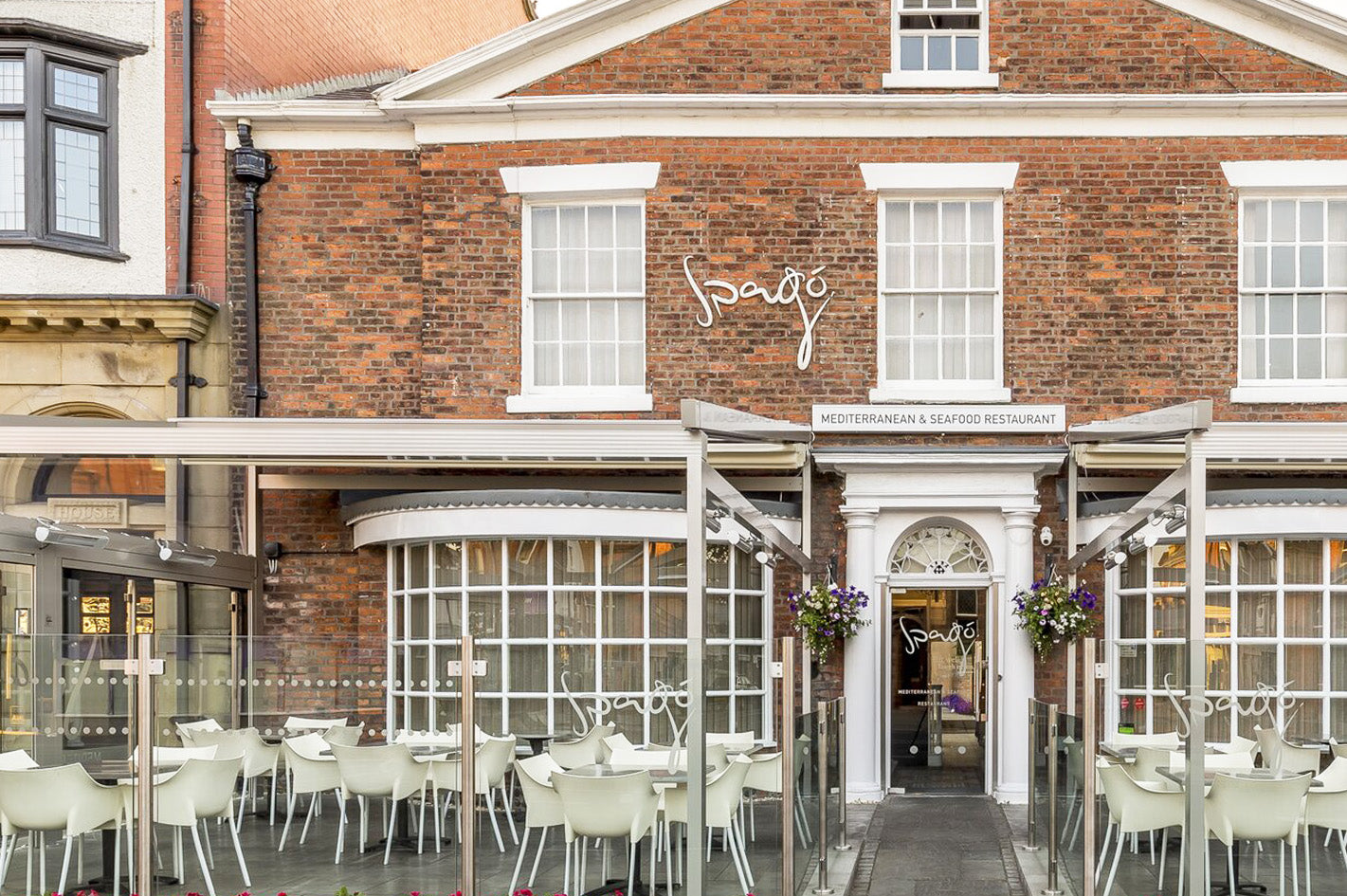 Luxury aluminium pergola with glass panels covering outdoor restaurant seating area